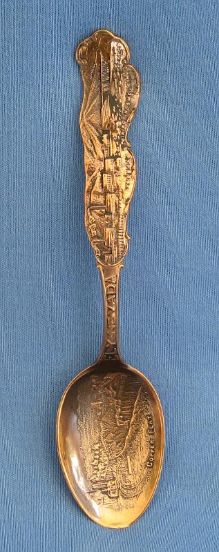 Souvenir Mining Spoon Copper Flat Ely Nevada.JPG - SOUVENIR MINING SPOON COPPER FLAT ELY NEVADA - Copper souvenir mining spoon, embossed scene of open pit copper mine in bowl with marking COPPER FLAT at bottom, handle is a skyline depiction of mountains with buildings and smokestacks and a bridge with ELY NEVADA marked on handle, Steptoe Mining and Smelting Co. is marked at the bottom of the skyline, reverse has Paye & Baker makers mark with Sterling x’ed out, 5 1/4 in. long, weight 21 grams [Copper Flat is today a general reference to the area in eastern Nevada where the great copper discoveries were made at the first of the 20th century.  Copper Flat was also small settlement for a short time in this area (now long gone) approximately 6 miles west of Ely, NV in White Pine County.  The Copper Flat area is also associated with several small towns including Kimberly, Riepetown, Ruth and Veteran. The famed open-pit copper mines of eastern Nevada, including the Liberty Pit (largest in the state), are located in this area between Ely and Ruth just south of Highway 50. Through the first half of the 20th century, this area produced nearly a billion dollars in copper, gold and silver. The first mining claims were filed in White Pine County, Nevada, as early as 1867, and the first copper claim was filed in the summer of 1900.  Over the next couple years, an additional 26 claims covering 437 acres of the Copper Flat area were filed.  The Nevada Consolidated Copper Company was organized and incorporated under the laws of Maine on November 17, 1904 to buy up and operate these claims. By May 1906, the company was controlled by the Guggenheim family and their associates and in 1907, steam shovels began stripping the overburden above the Eureka mine to start the open pit mining operations.  In 1906, the Nevada Consolidated Copper Company and the Cumberland and Ely Mining Corporation formed a partnership to build a smelter in the area to process the ores from Copper Flat.  Named the Steptoe Valley Mining and Smelting Company, the smelter started construction in December 1906 at the small town of McGill some 12 miles north of Ely.  The smelter was completed and operations began on May 15, 1908.  The first copper was shipped from the smelter on August 7 of the same year. Kennecott Utah Copper acquired Nevada Consolidated Copper Company, which included Steptoe Valley Mining and Smelting Company and the smelter at McGill, in 1932. In 1983, the price of copper along with the low grade ore being mined led to Kennecott closing the smelter and demolishing it.]